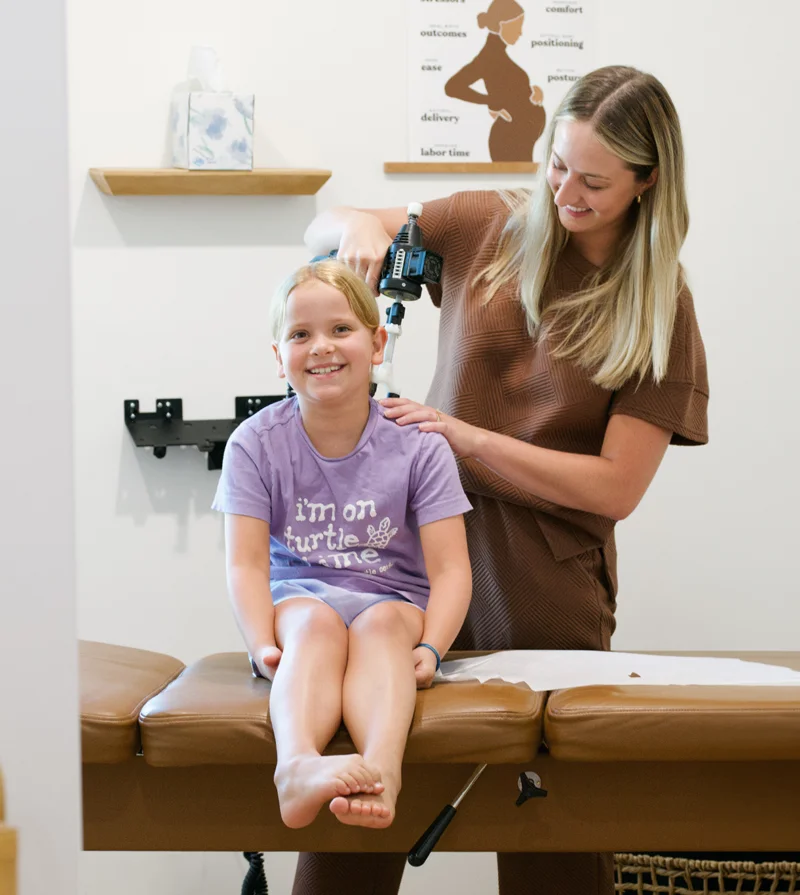 A pediatric patient sitting for an adjustment with Dr. Malori